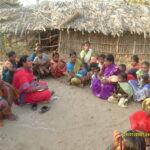 Women gathering in a makeshift Adivasi village